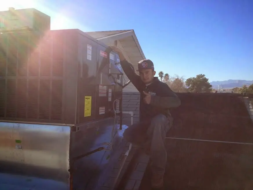 HVAC technician performing Boiler Repair on a rooftop unit in Sheldon